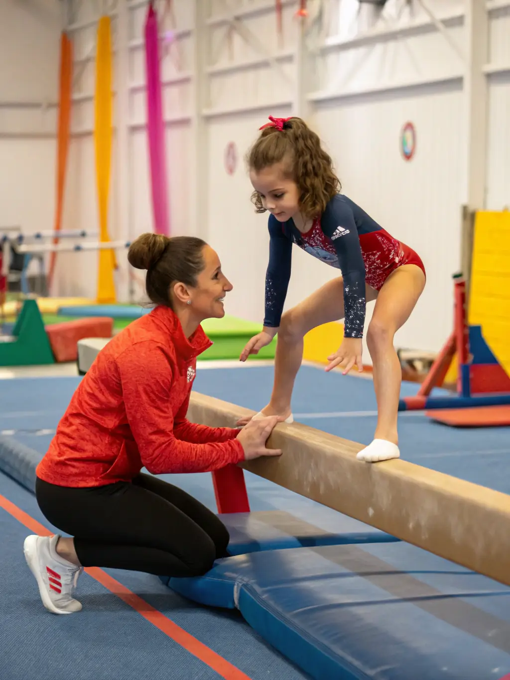 A young adult practicing advanced gymnastics techniques on specialized equipment, showcasing strength, agility, and precision, under the supervision of experienced coaches at AMICALE GYM TONIC.
